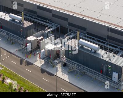 Aerial view of an AI data center power generator system featuring large industrial containers, concrete housing, and complex piping infrastructure in Stock Photo
