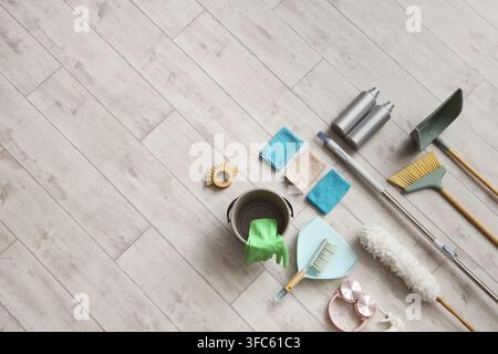 Home cleaning and household chores concept, various cleaning supplies and tools on a light wooden floor Stock Photo