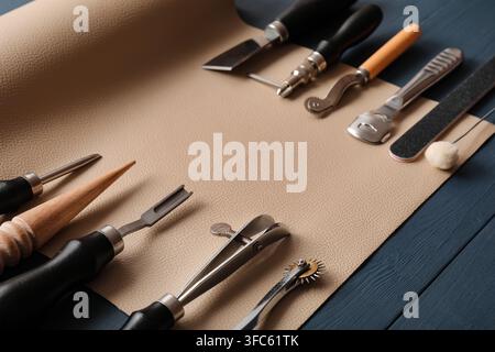 Leather crafting tools and materials for handmade goods, artisan workshop and hobby, creative DIY project on wooden background Stock Photo