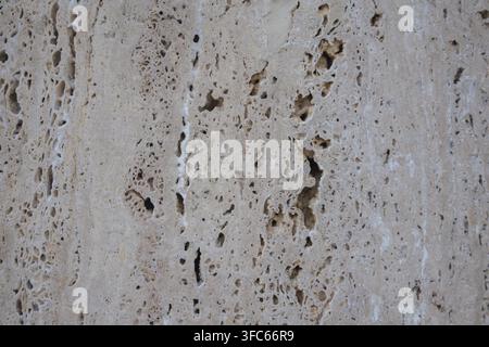 Natural beige travertine stone texture with porous surface. Stock Photo