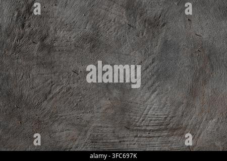 Full frame neutral dark gray stone cement wall texture ideal for background design and graphic placement Stock Photo