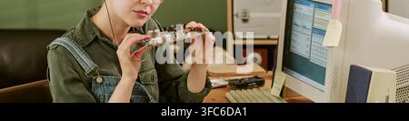 Header of Woman Repairing Vintage Circuit Board in Retro Office Workspace Stock Photo