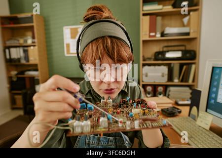 Woman Repairing Vintage Circuit Board in Retro Office Stock Photo