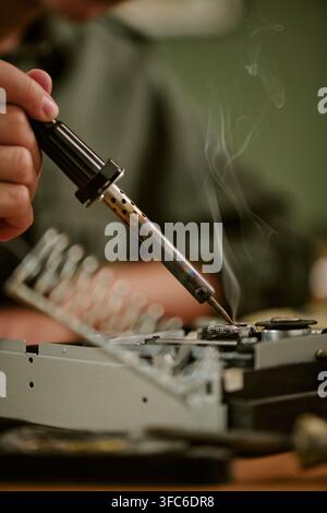 Worker Soldering Vintage Electronic Device in Retro Office Stock Photo