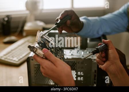 Diverse Colleagues Repairing Retro Computer Hardware in Office Stock Photo