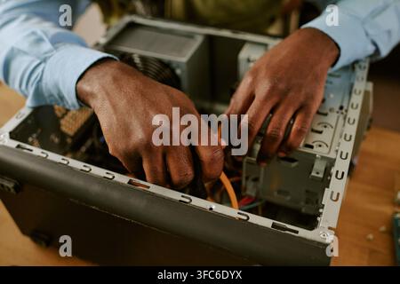 Hands of Black Man Repairing Retro Computer in Office Stock Photo