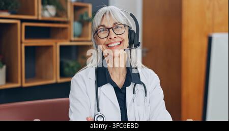 Doctor, portrait and happy woman with headset, telehealth or healthcare on virtual meeting in office. Health, advice and mature person with technology Stock Photo