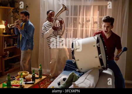 Excited Diverse Men Playing Musical Instruments Celebrating Football Victory Stock Photo