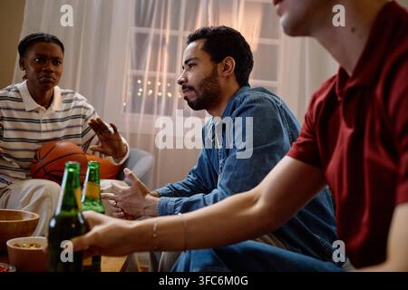 Diverse Men Watching Sports Game on Television at Home Stock Photo