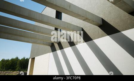 Modern concrete brutalist architecture with abstract geometric shadows and beams on facade Stock Photo