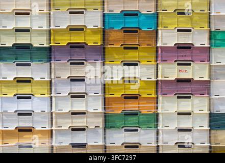Stacked colored fish plastic boxes wrapped in polythene Stock Photo