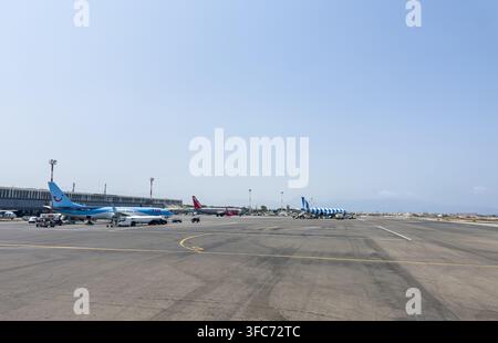 Airplanes from various airlines like TUI. Ryanair. And Aegean Airlines parked on the tarmac. With ground support vehicles near the terminal building a Stock Photo