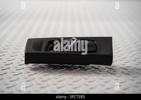 An automotive headlight control switch panel with rotary lighting selector is isolated on a white studio background. Stock Photo