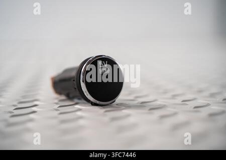 A compact automotive 5V power and charging socket is isolated on a white studio background. Stock Photo