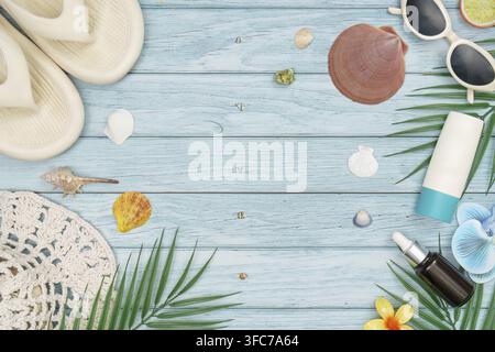 View from above of summer's most important beach items such as sunscreen, serum, flip flops and a straw hat on a blue wooden background Stock Photo