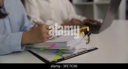 Colleagues work together on financial documents and review and comment on reports for business planning Stock Photo