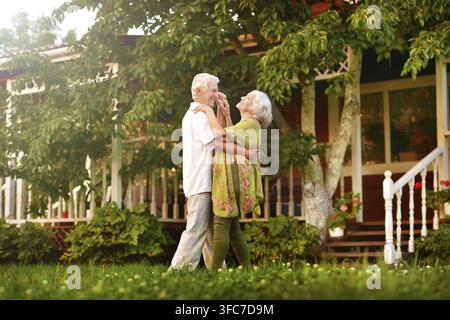 Beautiful elderly couple dancing in apple orchard Stock Photo