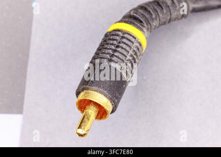 RCA phono audio video cable connector with gold-plated tip on gray background Stock Photo