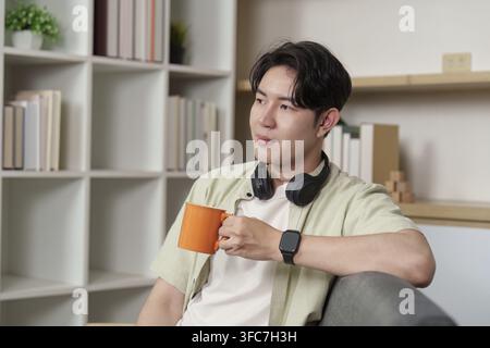 Relax. Young man enjoying coffee while sitting on the couch Stock Photo
