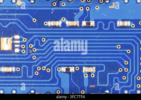 Blue Circuit Board Surface featuring Electronic Pathways and Tiny Components Stock Photo