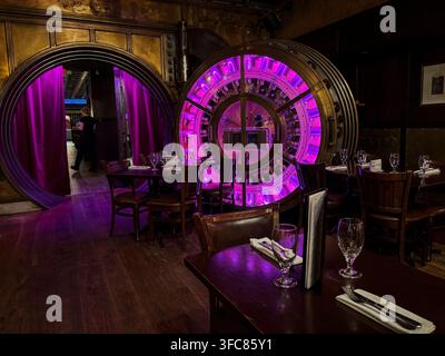 Tables set in front of the illuminated door of the former bank vault of Trinity Place. New York, New York, United States, 17 August 2026. Stock Photo