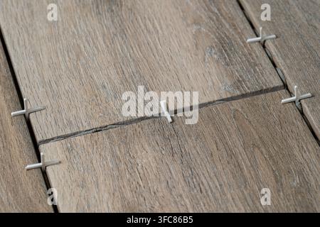 Laying ceramic tiles using plastic crosses. Renovation or repair concept. Close up Stock Photo