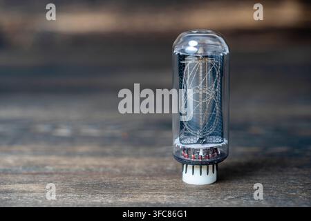 Retro vacuum lamp on a wooden background, close up, nixie tube indicator. Glow discharge indicator Stock Photo