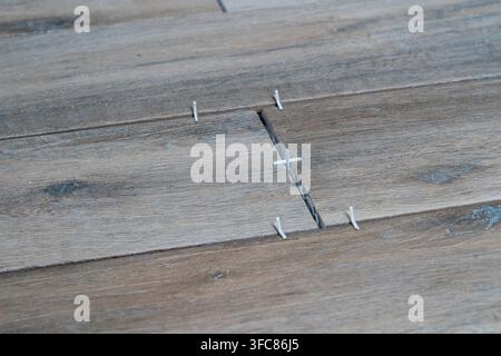 Laying ceramic tiles using plastic crosses. Renovation or repair concept. Close up Stock Photo