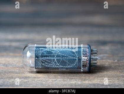 Retro vacuum lamp on a wooden background, close up, nixie tube indicator. Glow discharge indicator Stock Photo