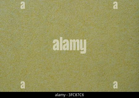 Yellow ocher stucco texture on exterior wall with fine grains. Sandpaper like sandy gritty rough surface in closeup view, patterns and textures concep Stock Photo