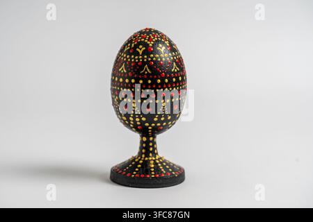 Colorful handmade wooden easter egg on a white background. Hand painted easter eggs with acrylic paints, handwork, dot painting, close up, Ukraine Stock Photo