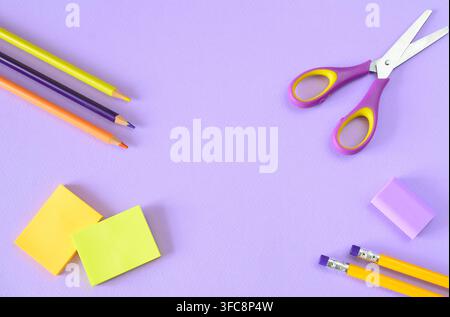 School Supplies Arranged on Purple Background, multicolored supplies, copy space, flat lay Stock Photo
