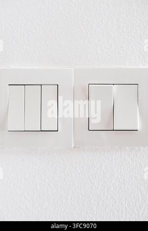Modern white light switch panels on a clean wall Stock Photo
