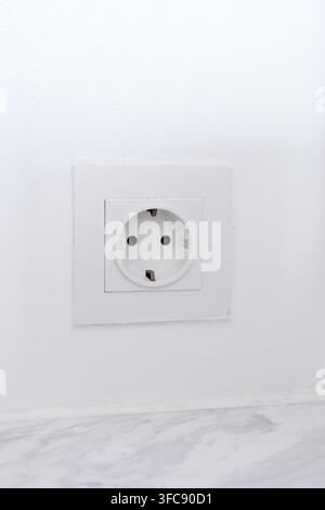 White electric power socket and wall outlet on a white wall Stock Photo