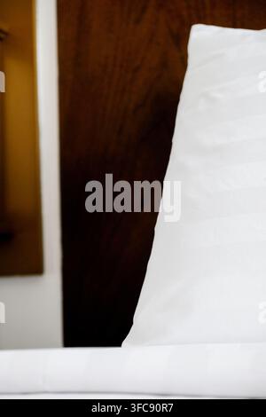 Clean and fluffy white hotel pillows arranged neatly on a bed Stock Photo