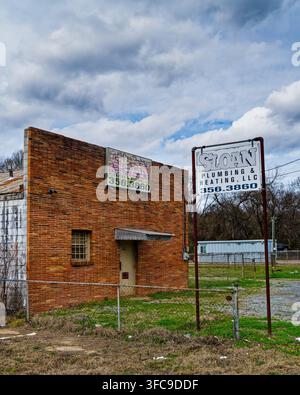 Front exterior of old vintage red brick building once occupied by Sloan Plumbing now abandoned in Montgomery Alabama, USA. Stock Photo