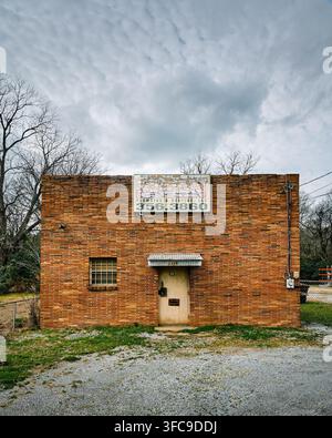 Front exterior of old vintage red brick building once occupied by Sloan Plumbing now abandoned in Montgomery Alabama, USA. Stock Photo