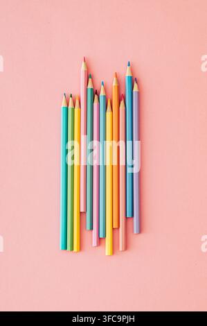 Colorful colored pencils on pastel pink background. Minimal school and creative education concept. Flat lay style. Top view. Stock Photo