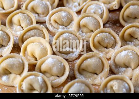 Raw Homemade Pelmeni Dumplings on a Wooden Board with Flour Stock Photo