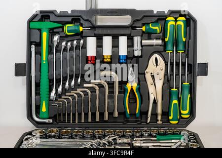 Professional tool kit with socket set, wrenches, screwdrivers, pliers and hex keys arranged in a protective case for mechanical repair and maintenance Stock Photo