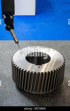 Precision measurement of a large industrial gear using a coordinate measuring machine, advanced metrology equipment for quality control Stock Photo
