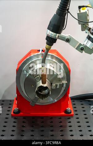 Industrial CNC machining setup with precision tool head, metal component and rotary chuck on a machine table, modern manufacturing equipment Stock Photo