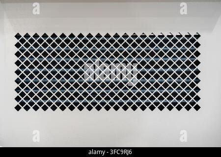 Close-up of ventilation grille with diamond mesh pattern protecting heat exchanger radiator fins in industrial HVAC cooling system Stock Photo