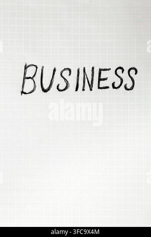 Word 'BUSINESS' written in bold, hand-drawn style on white grid paper. Clean, minimalist aesthetic with crisp lines Stock Photo