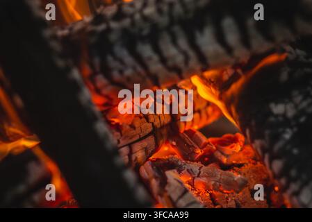 Burning firewood and glowing embers in a campfire outdoors, camping, bushcraft and survival concept. Stock Photo