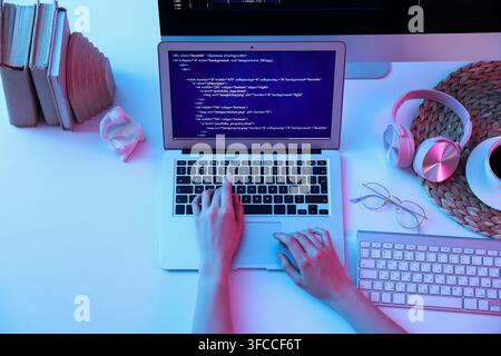 Female programmers hands working with laptop on table, top view Stock Photo