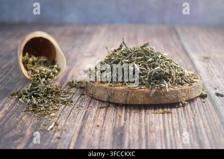 Dried tea leaves placed on a wooden surface Stock Photo