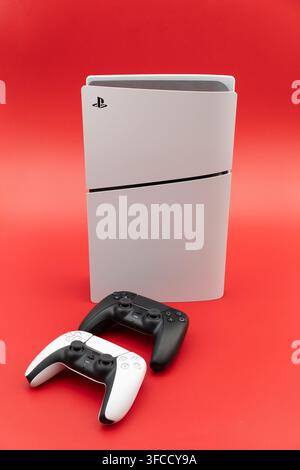 Playstation 5 slim console standing with two dualsense controllers for gaming entertainment Stock Photo