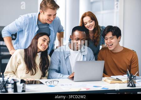 Group of international people using laptop and smiling Stock Photo