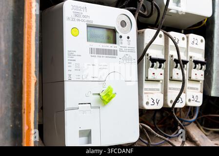 Electric meter and numbered circuit breakers in distribution box, smart electricity counter with handwritten switches, energy consumption measurement, Stock Photo